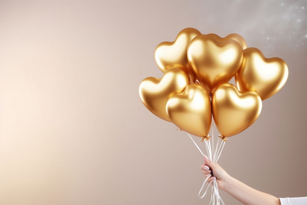 Hands hold aluminium gold hearts shaped balloons celebration anniversary decoration. AI generated Image by rawpixel.