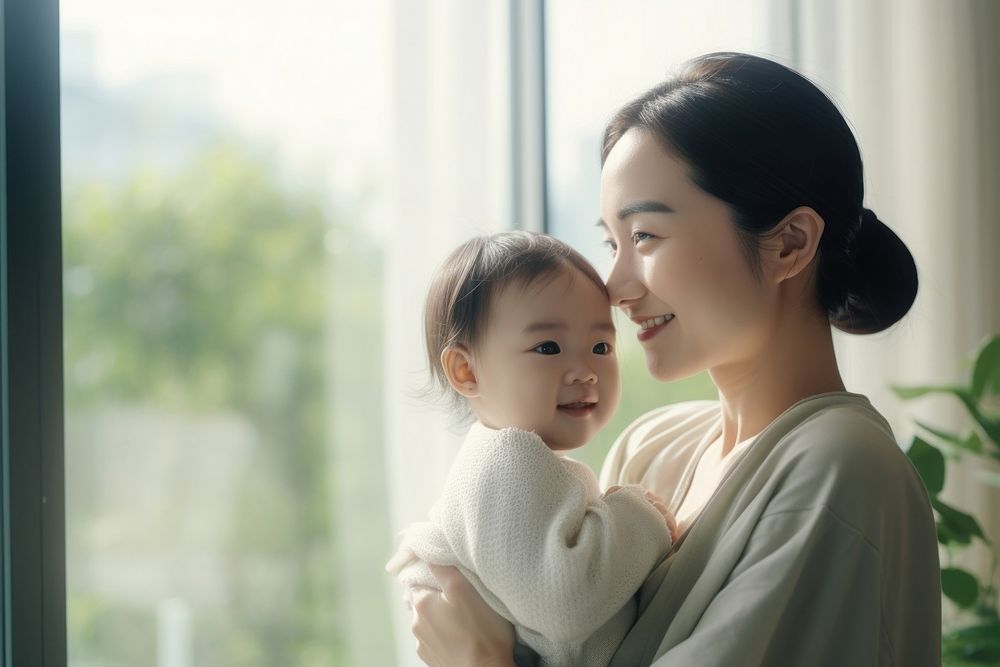 Local Asian woman looking at her baby daughter in her arms bonding family love. AI generated Image by rawpixel.
