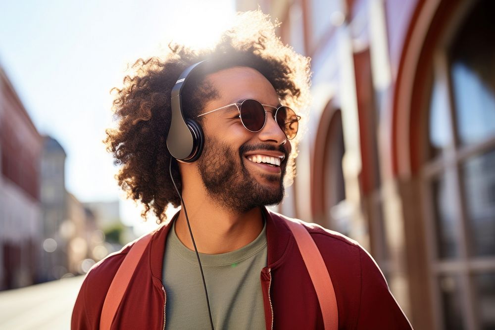 Young man enjoying music while walking in the wall streets headphones headset glasses. AI generated Image by rawpixel.