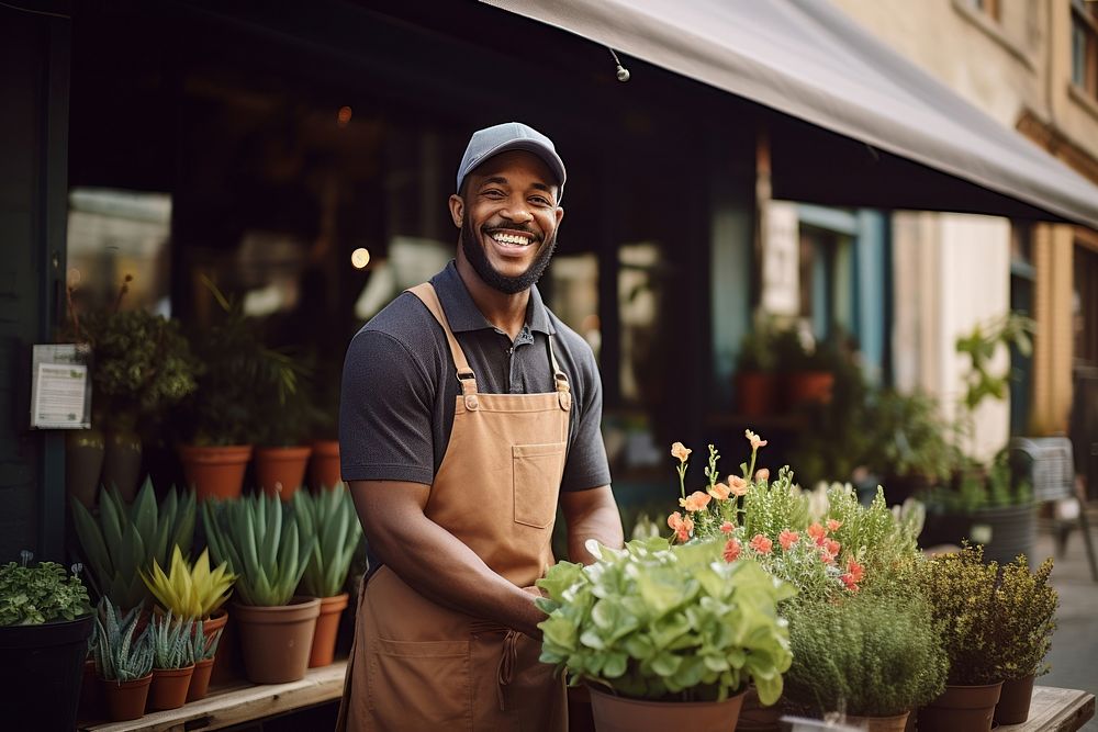 A multiracial man holding a potted plants in front of plant shop outdoors gardening working. AI generated Image by rawpixel.