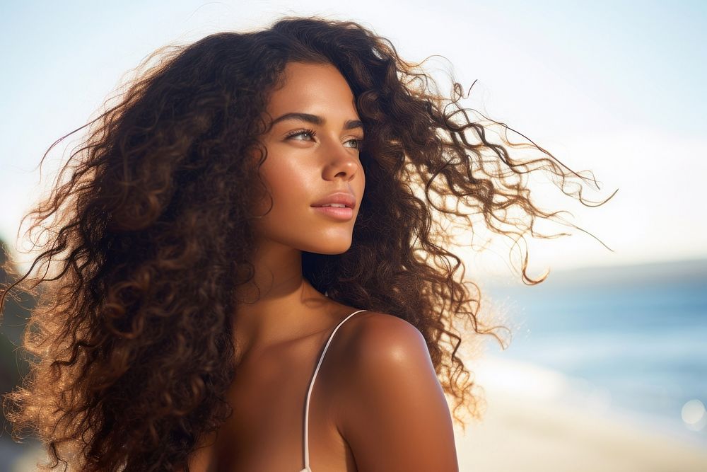 A Latina Brazilian woman standing with her hair gathered by the seaside portrait summer adult. AI generated Image by…