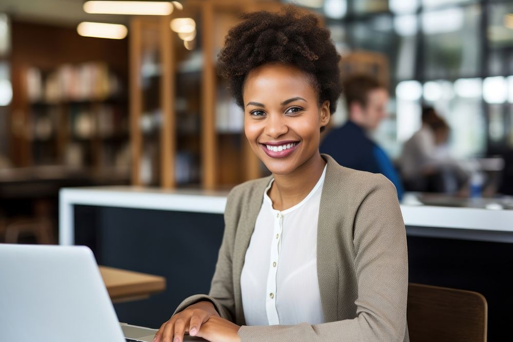 South African businesswoman using a computer smiling laptop office. AI generated Image by rawpixel.