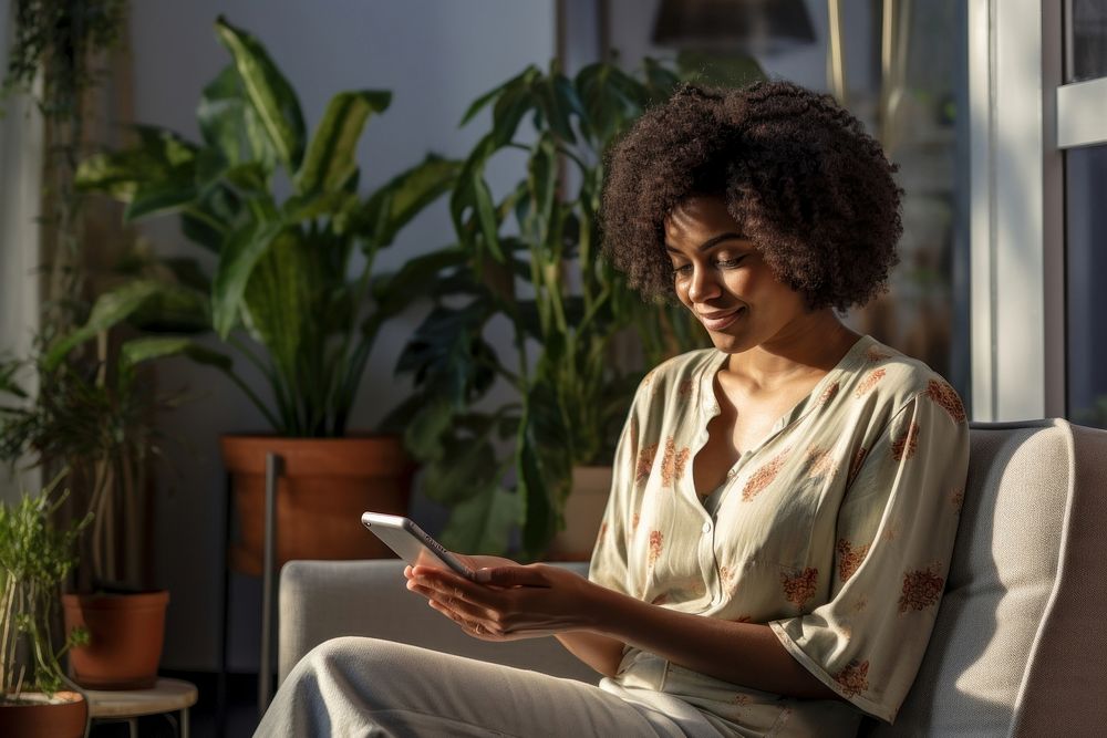 Ethiopian woman texting on her smartphone sitting adult plant. AI generated Image by rawpixel.