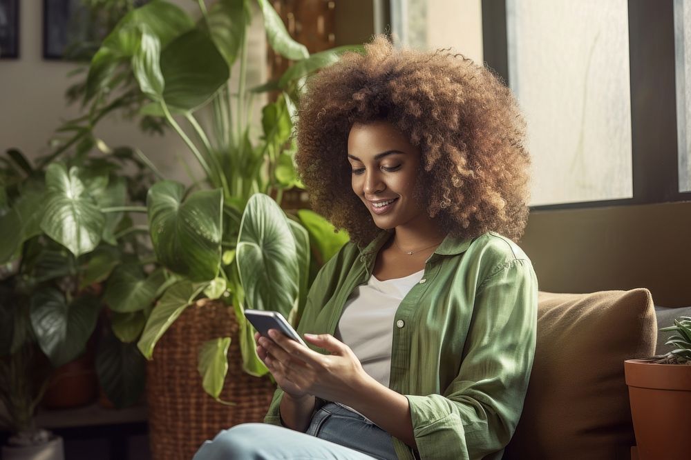 Ethiopian woman texting on her smartphone sitting adult sofa. AI generated Image by rawpixel.