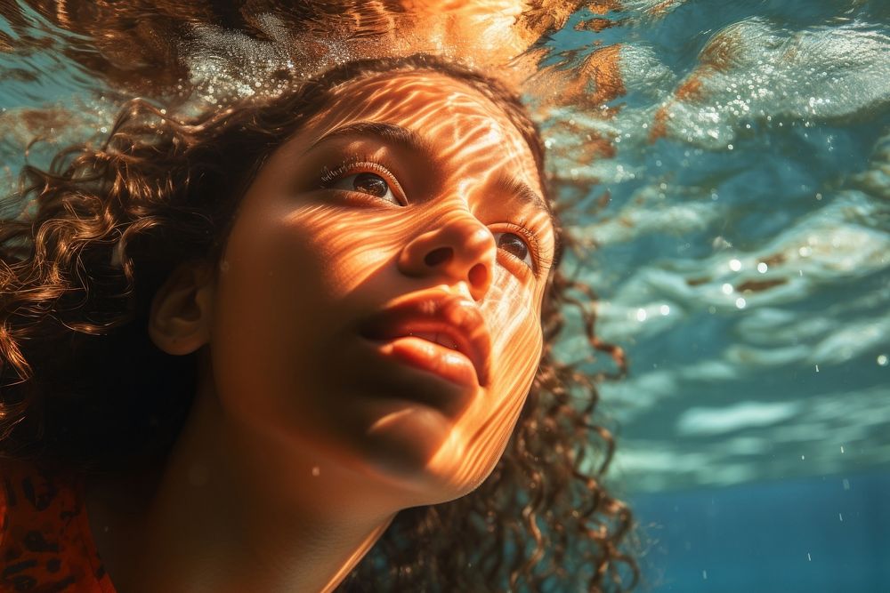 A Latina Brazilian teenage girl enjoying her time swimming underwater portrait outdoors nature. AI generated Image by…