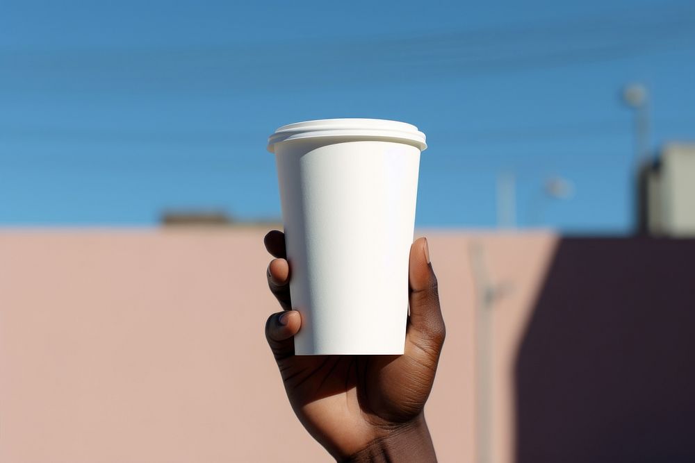 Black person hand holding white paper coffee cup mug refreshment disposable. AI generated Image by rawpixel.