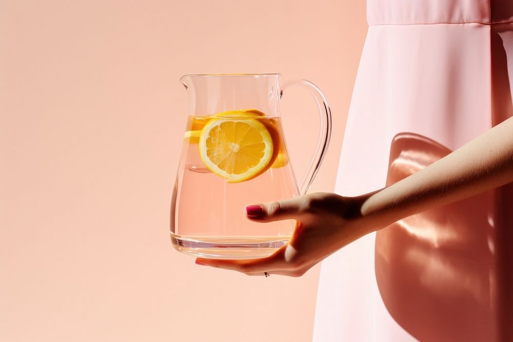 Female holding clear pitcher of water yellow fruit glass. AI generated Image by rawpixel.