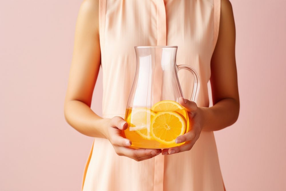 Female holding clear pitcher of water glass yellow juice. AI generated Image by rawpixel.