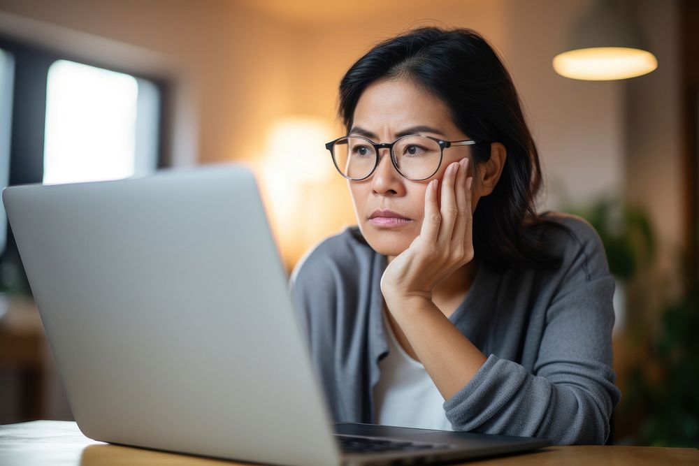Woman working from home computer worried looking. 