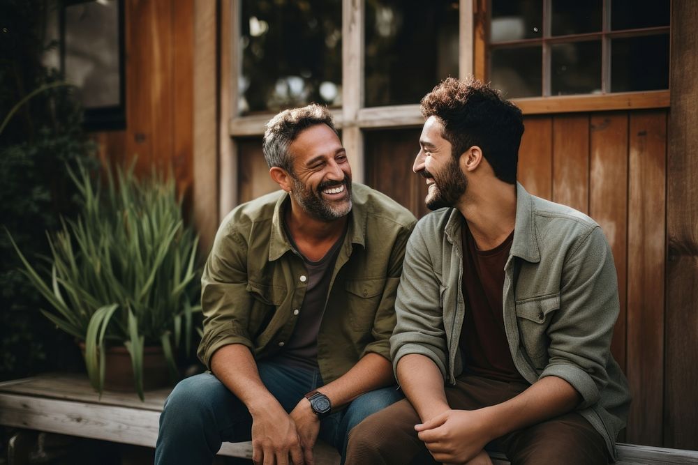 Gay hispanic couple talking together laughing outdoors adult. AI generated Image by rawpixel.