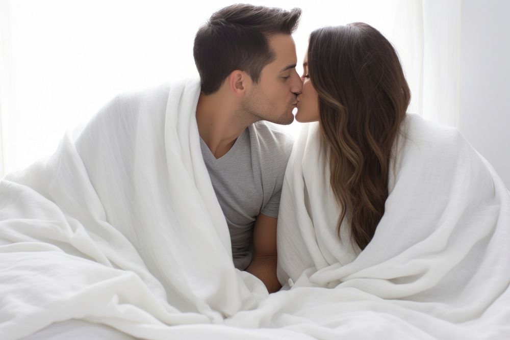 Hispanic couple kissing under the blanket adult affectionate togetherness. AI generated Image by rawpixel.