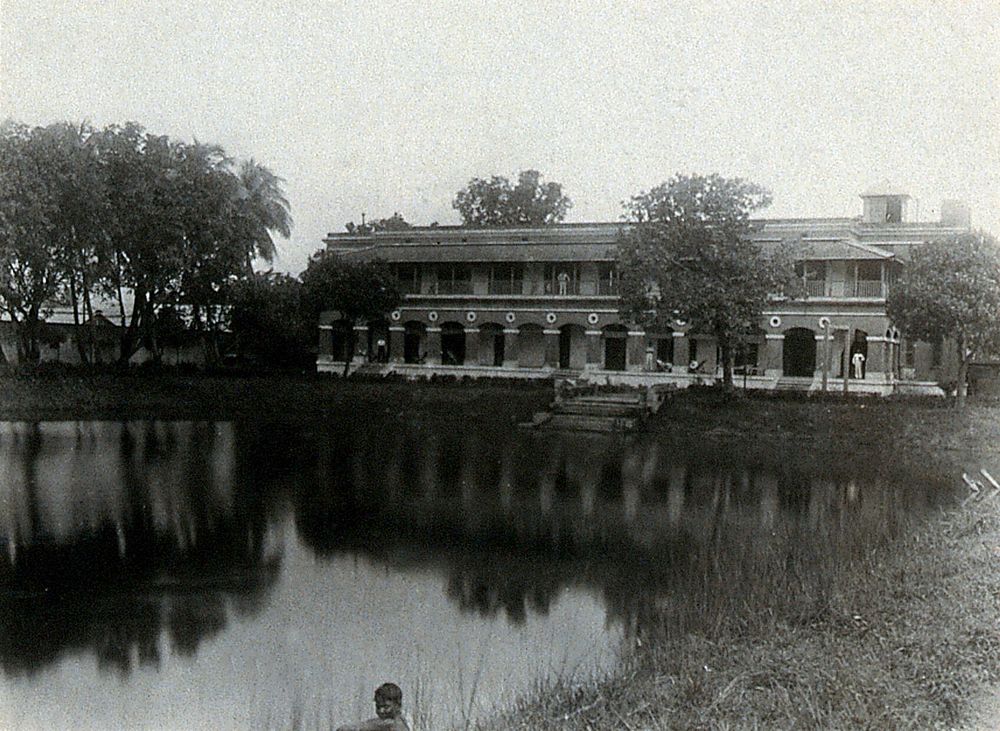 The Albert Victor asylum for lepers, Gohea, Calcutta, India: view of the lake and asylum building. Photograph, 1900/1920.