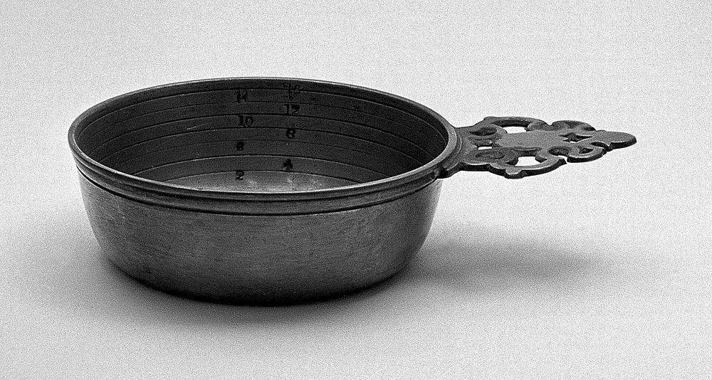 Pewter bleeding bowl, with pierced handle, 17th to 18th century.