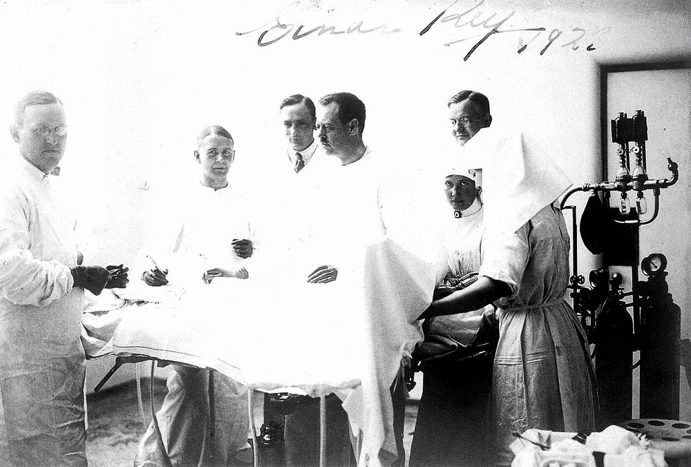 Einar Key (fourth from left), a Swedish surgeon, in an operating theatre with other surgical staff. Photograph.
