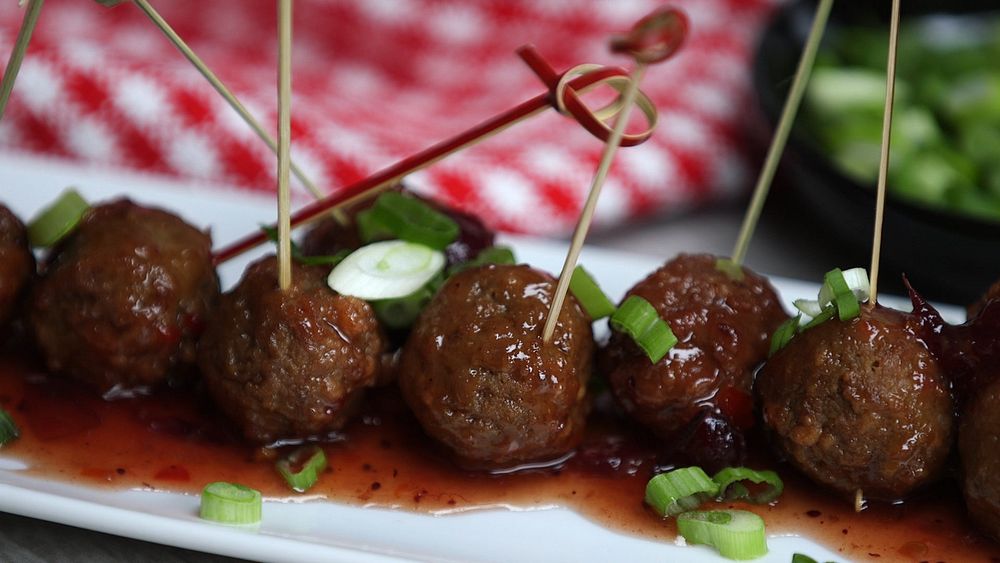 White appetizer plate full of meatball appetizers with sticks in them ready to eat!
