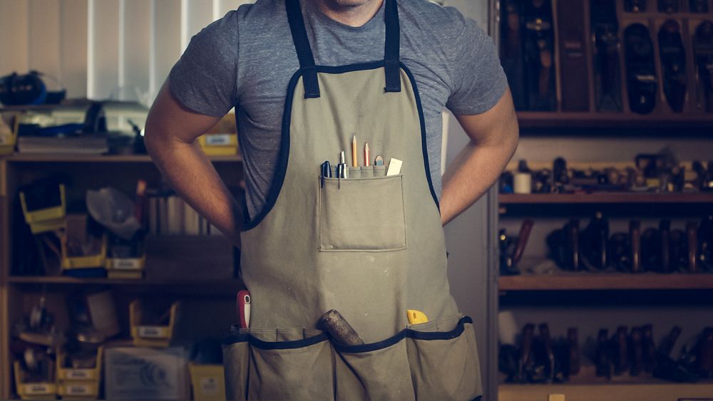 Handyman wearing apron with tools.