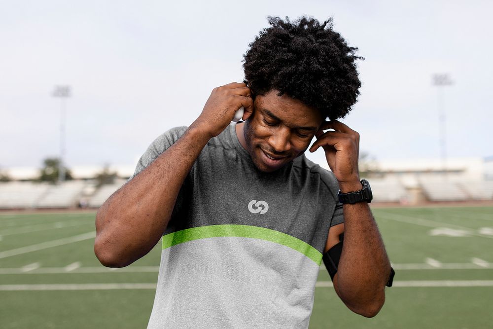 Man athlete putting the earbud on his ears and listening to the music 
