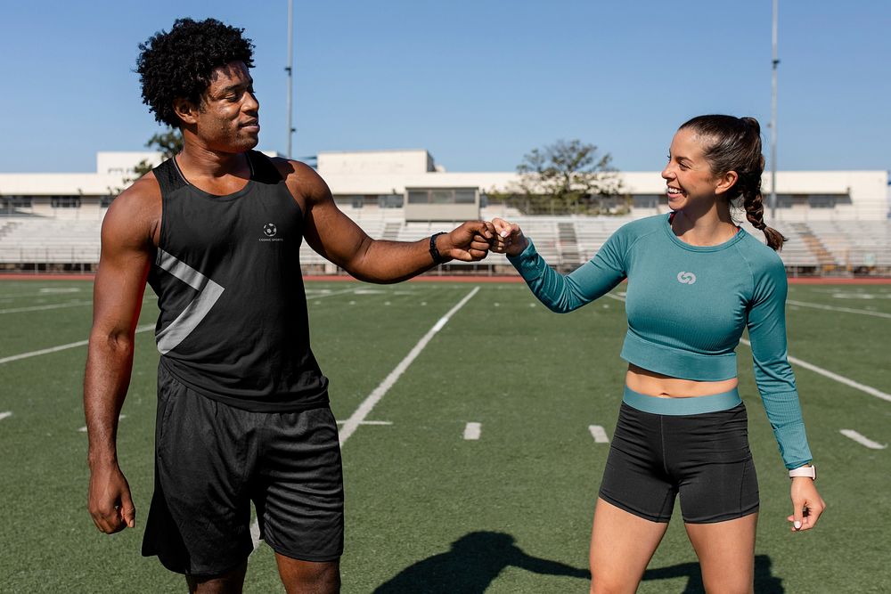 Male and female athletes fist bumping