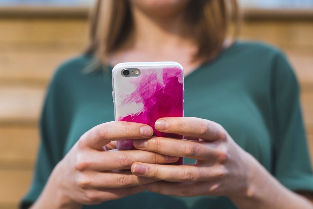 Free woman using iPhone with pink and white case image, public domain CC0 photo.