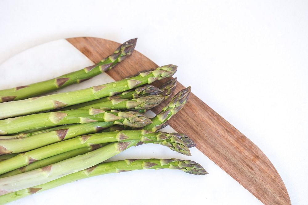 Free spears of asparagus lay prepped on a cutting board image, public domain CC0 photo.