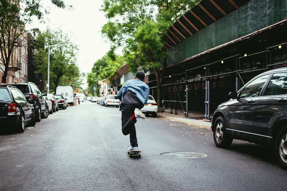 Free man skateboarding in city street public domain CC0 photo.