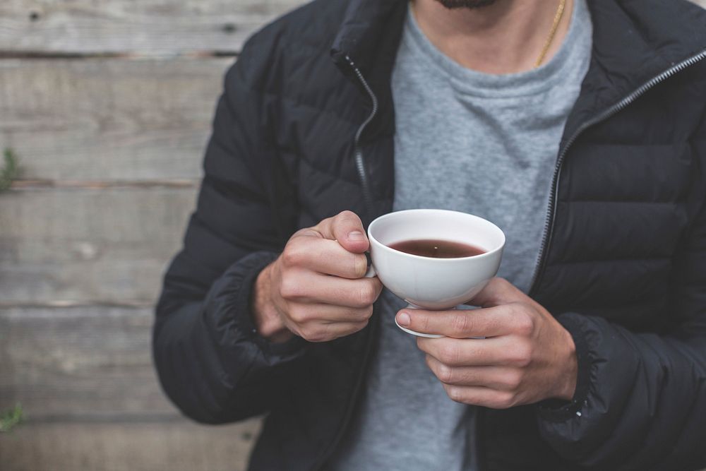 Free hand holding a cup of coffee photo, public domain drink CC0 image.