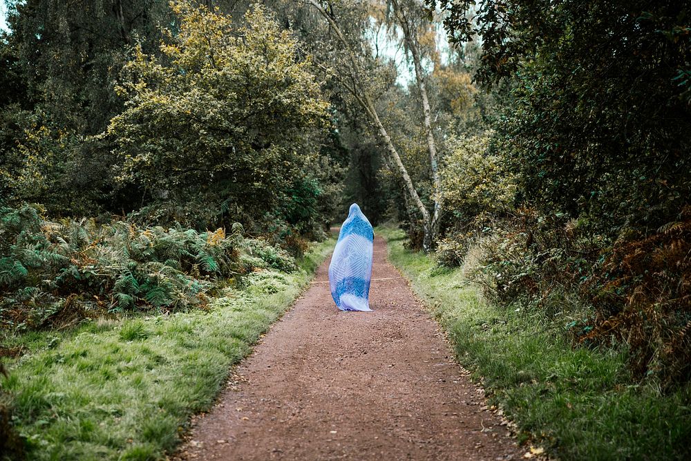Free woman in blue standing on forest path photo, public domain nature CC0 image.