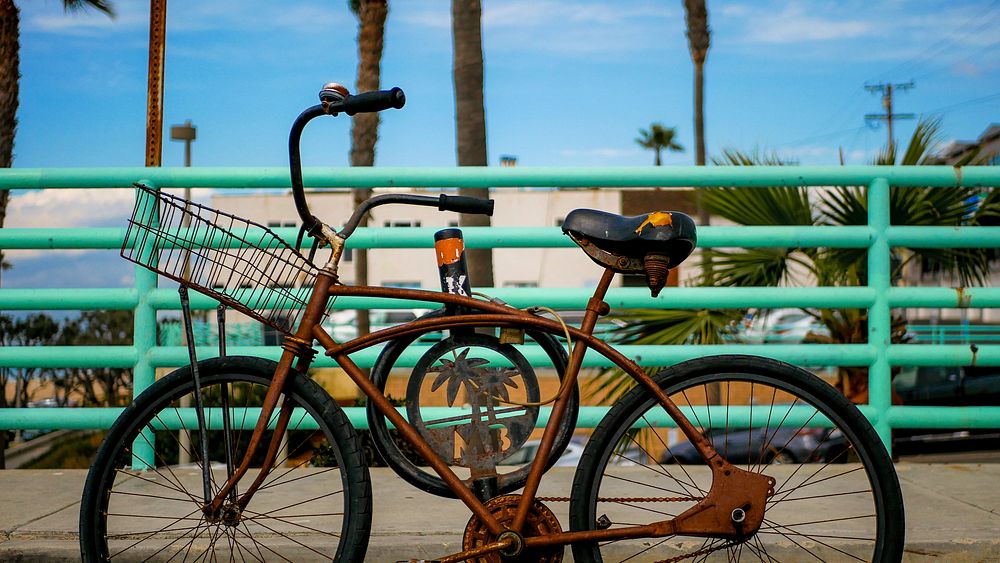 Free rusty bike parked against a boardwalk image, public domain vehicle CC0 photo.