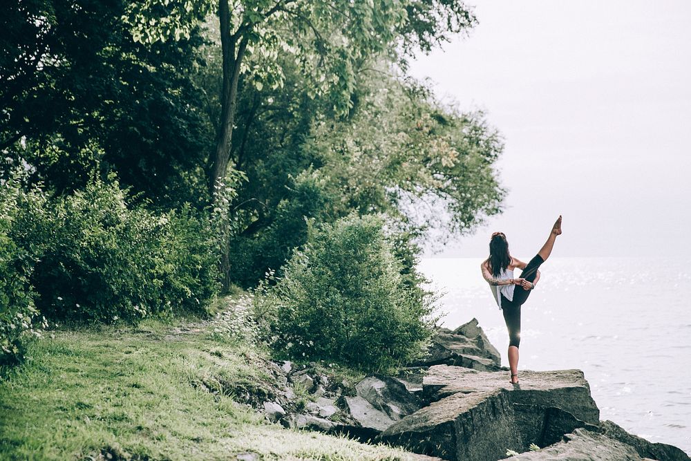 Freewoman stands on a rock outdoors in a Yoga pose photo, public domain sport CC0 image.