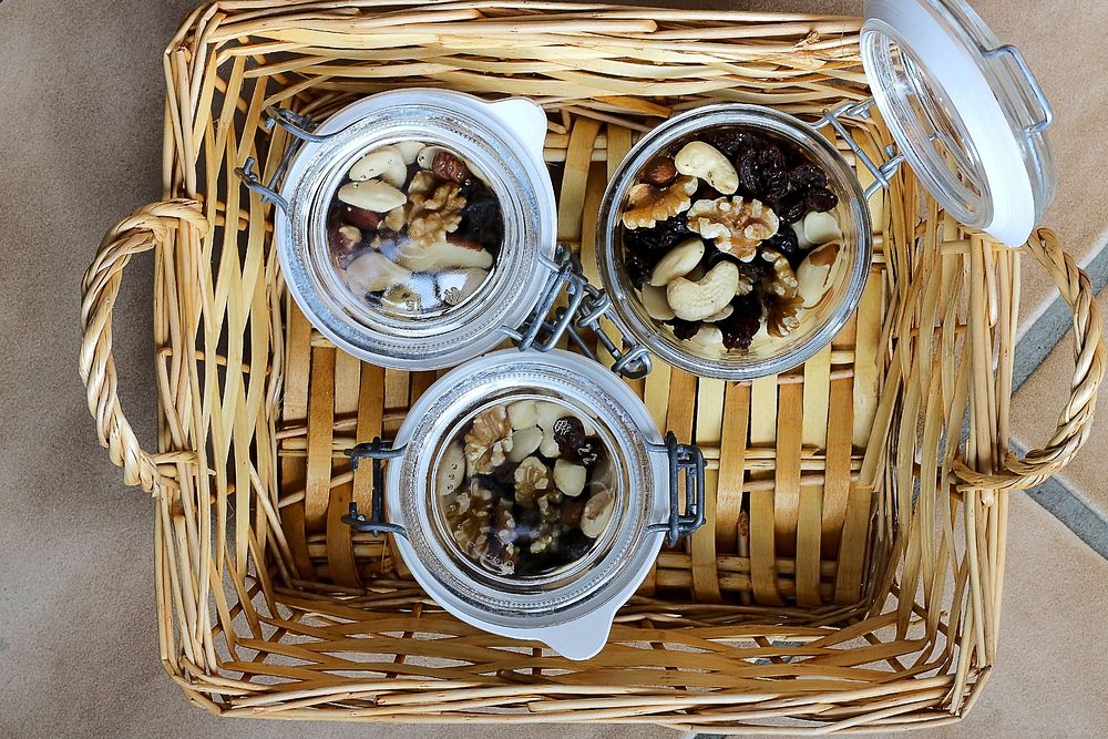 Top view of three glass jars filled with trail mix in a wicker basket, free public domain CC0 image.