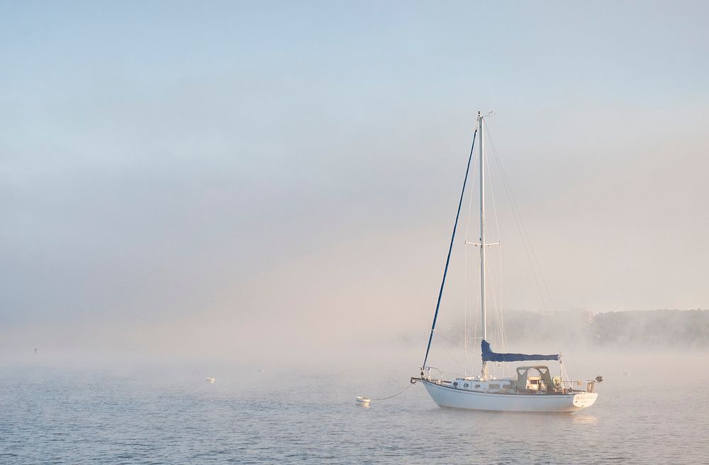 A sailing boat in foggy sea. Original public domain image from Flickr