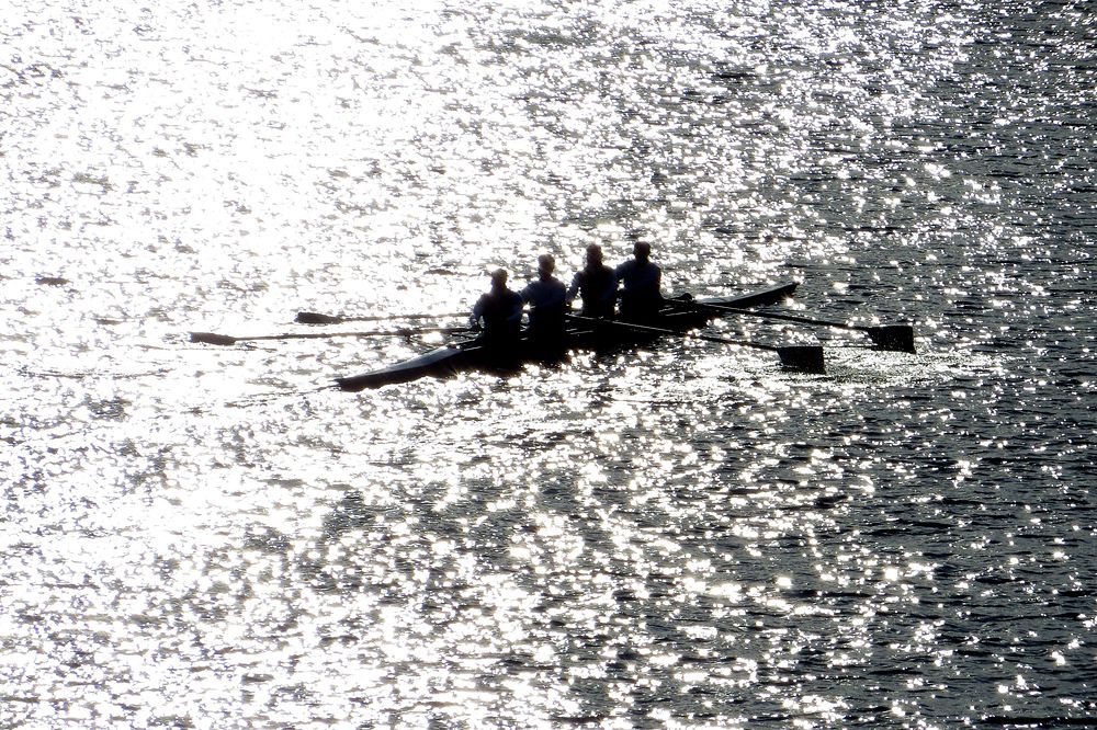 Men rowing a canoe on a sunny day. Original public domain image from Flickr