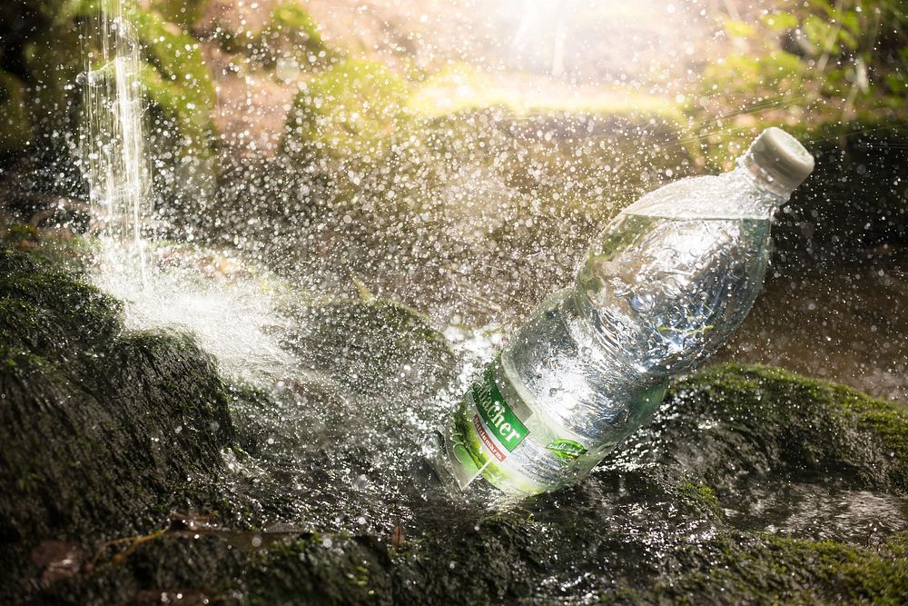 Water bottle on waterfall rock. Free public domain CC0 photo.