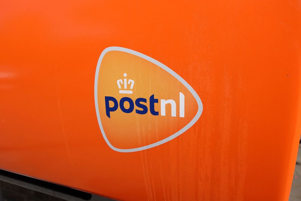 PostNL logo, Dutch mail corporation, orange public post box. Netherlands - April 30, 2017