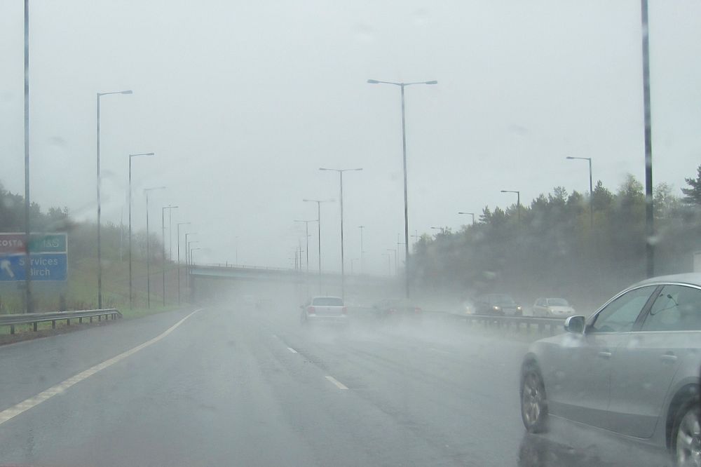 Cars driving on rainy highway. Original public domain image from Flickr