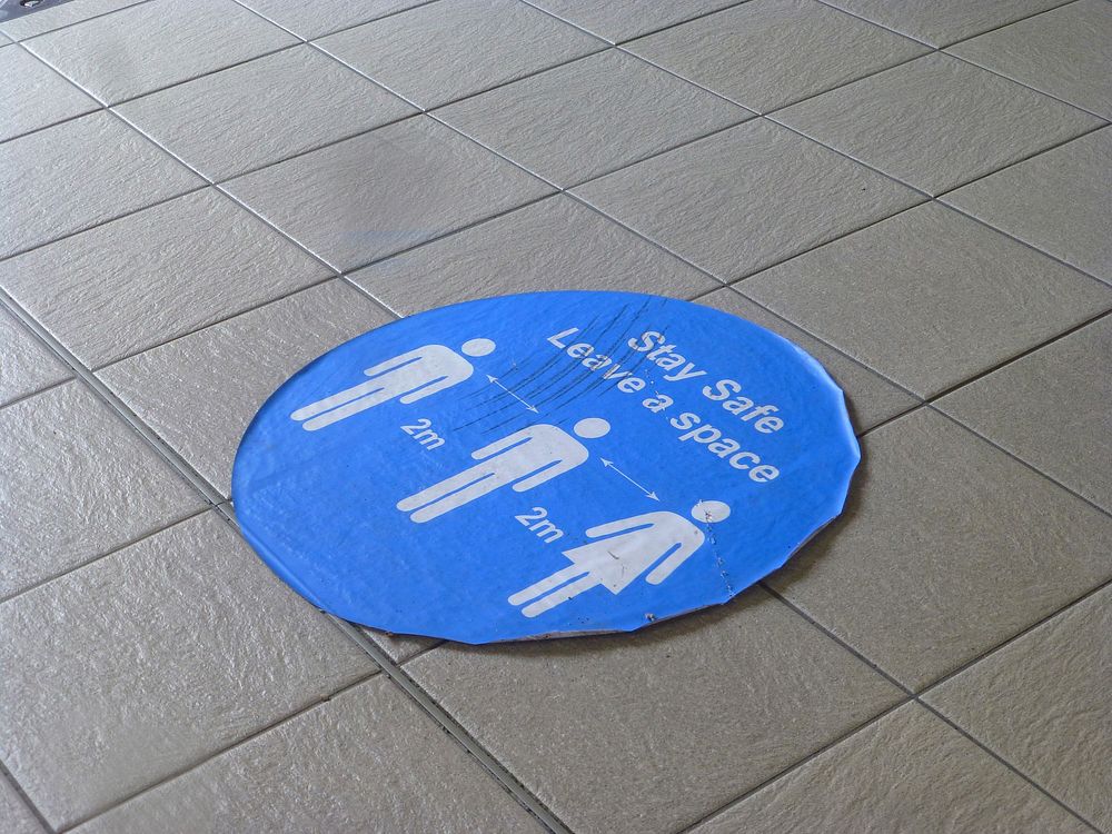 Social distancing sign on the ground. Free public domain CC0 photo
