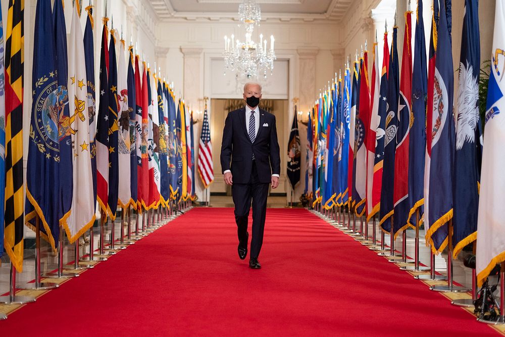 President Joe Biden walks from the State Dining Room of the White House to a podium in the Cross Hall of the White House…
