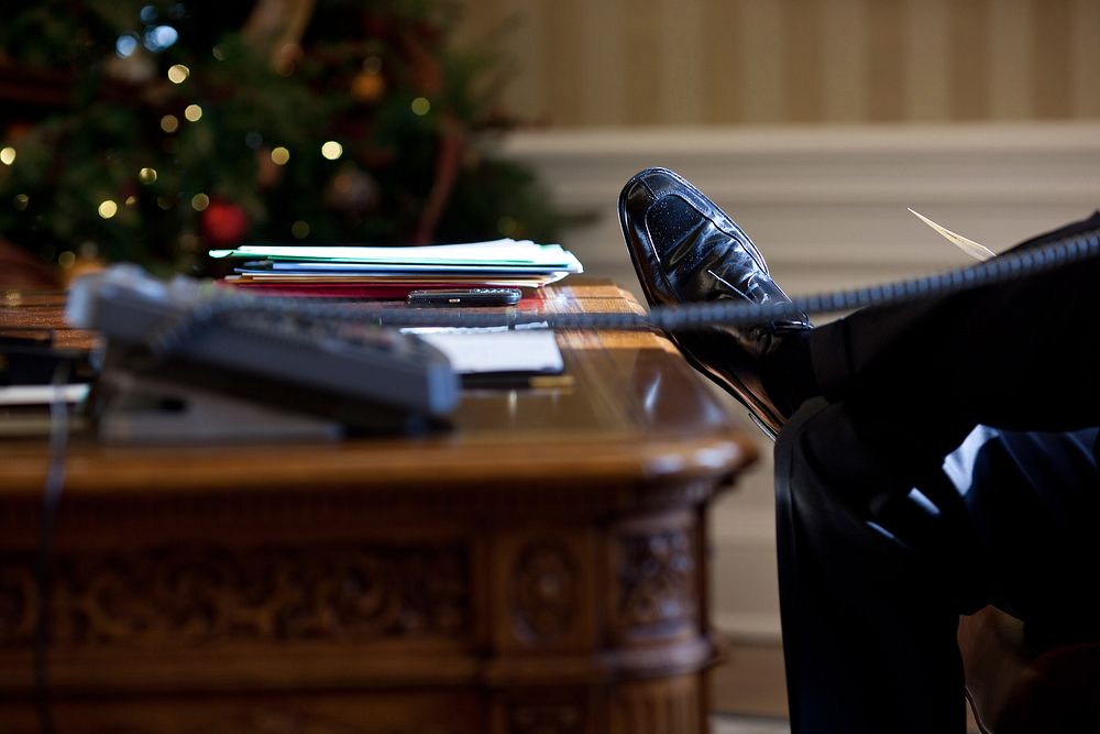President Barack Obama rests his foot on the Resolute Desk during a call with British Prime Minister David Cameron in the…