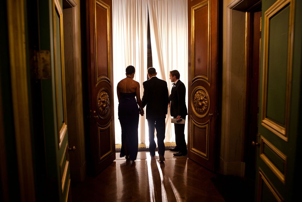 Joe Paulsen, White House Advance Office site lead, holds the curtain for President Barack Obama and First Lady Michelle…