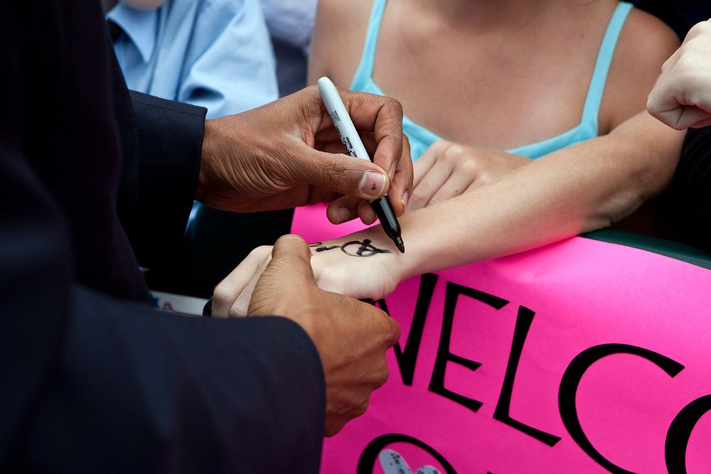 President Barack Obama signs a hand as he greets people at Minneapolis-St.