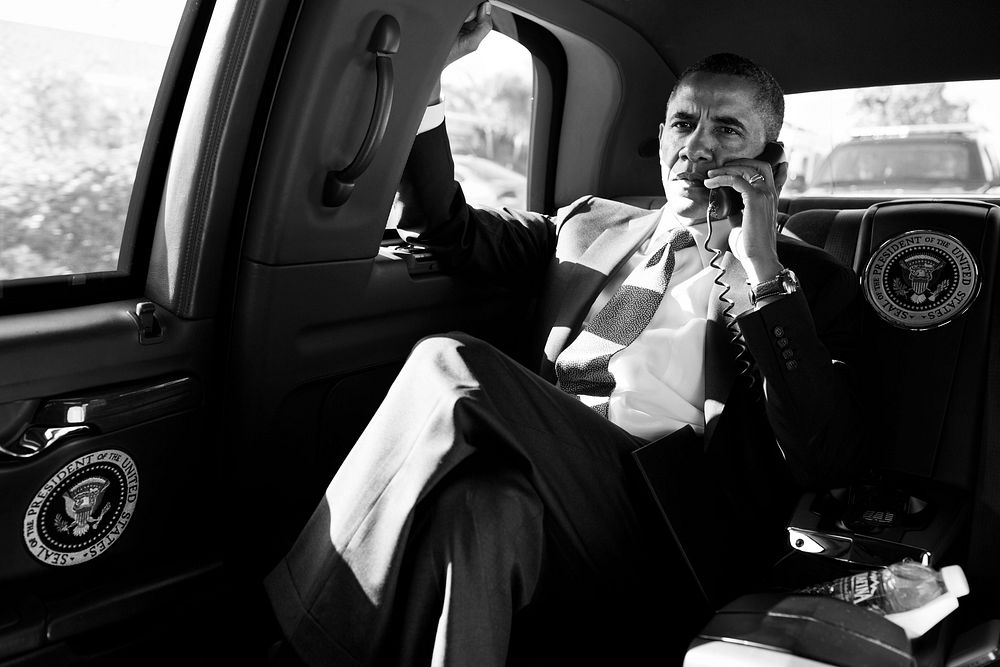 President Barack Obama holds a conference call with advisors to discuss the Aurora, Colorado shootings, during the motorcade…