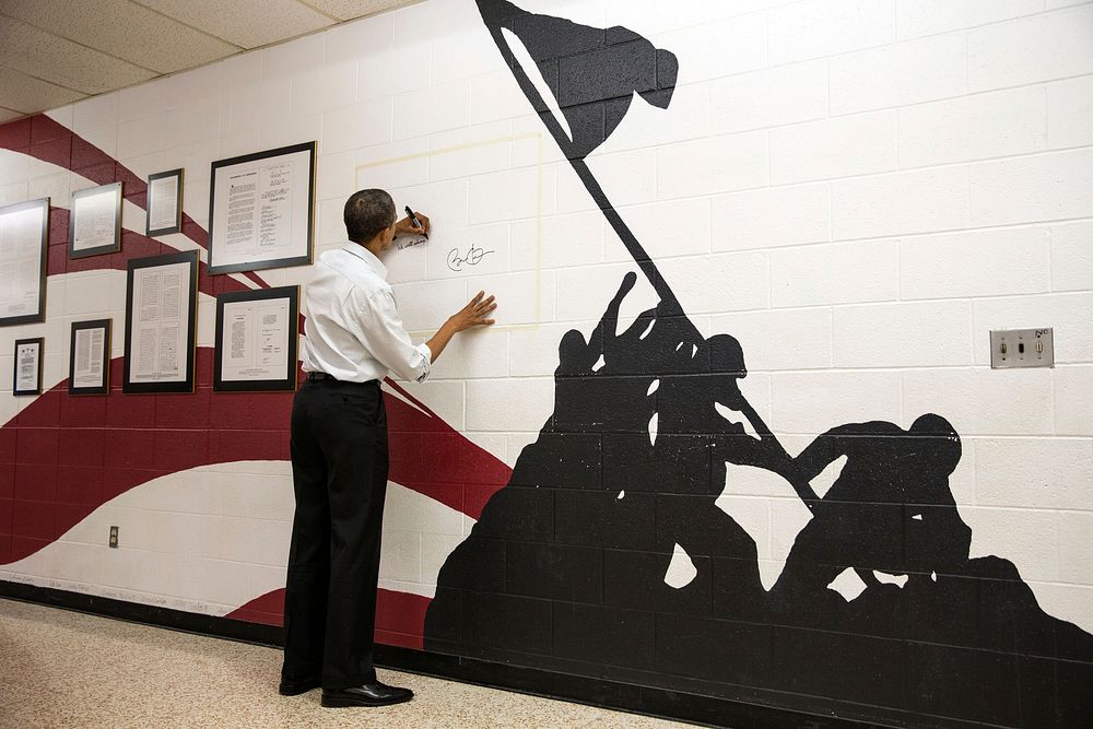 President Barack Obama signs the Wall of Freedom after an event at Mentor High School in Mentor, Ohio, Nov. 3, 2012.