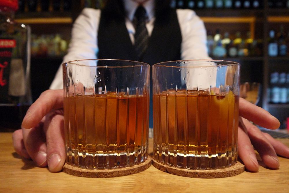 Bartender serving whiskey. Free public domain CC0 photo.