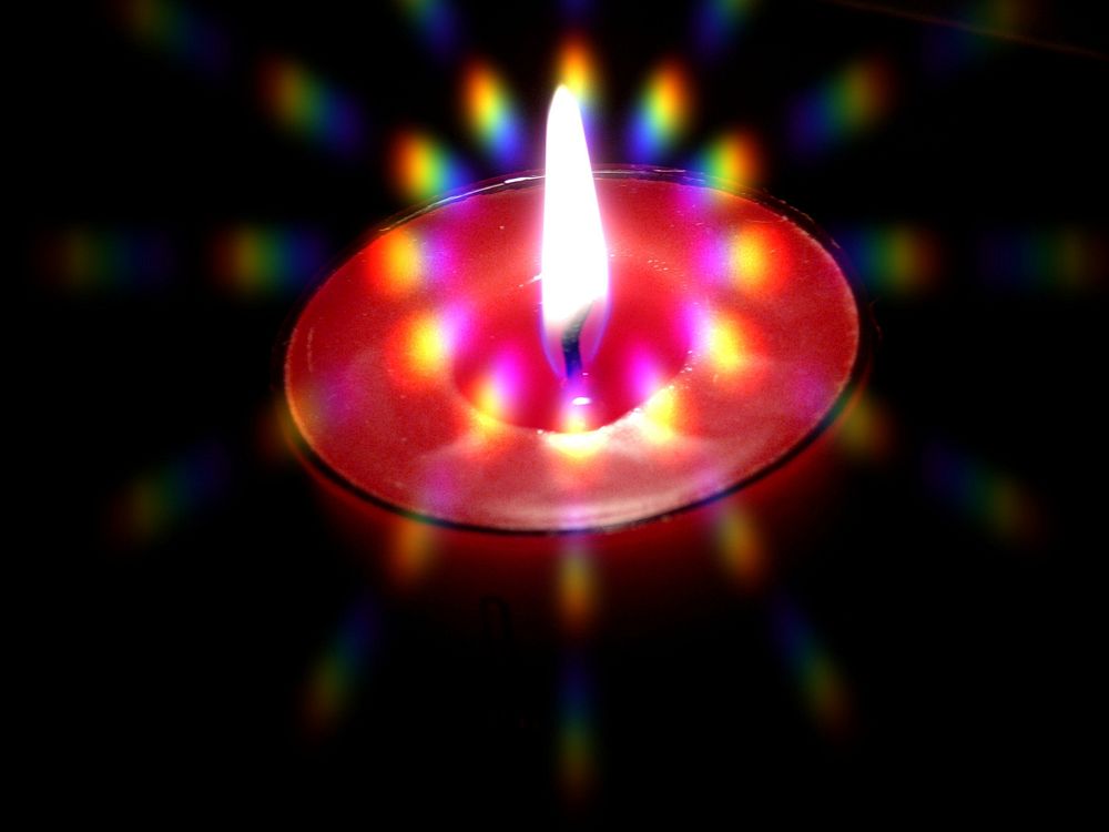 Burning red candle in the dark. Free public domain CC0 image.