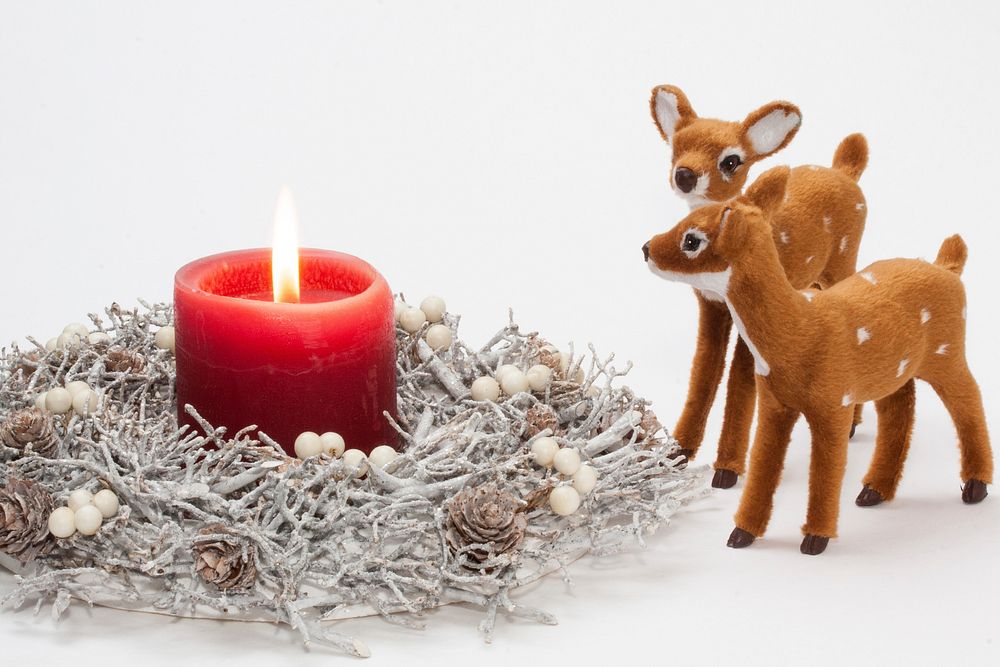 Red lit up candle with deer toy. Free public domain CC0 photo