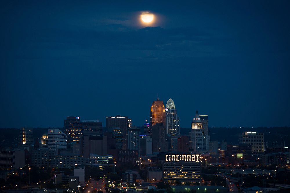 City at night with a full moon. Free public domain CC0 photo.