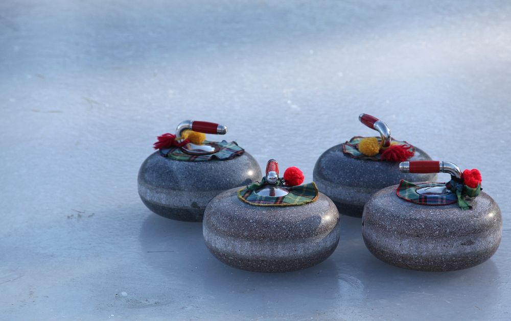 Closeup on curling rocks on ice. Free public domain CC0 photo.