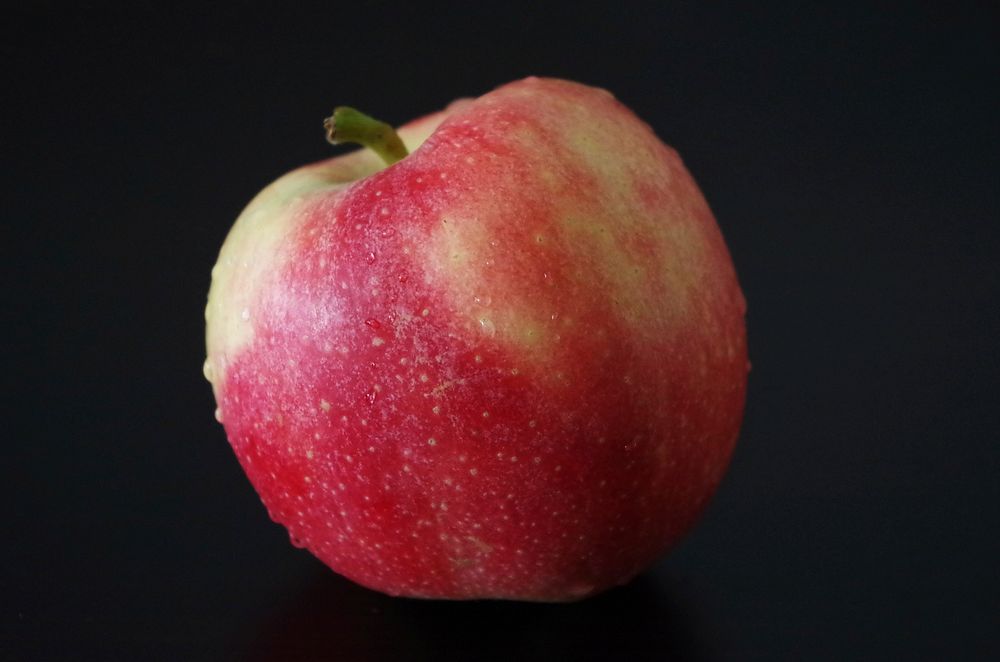 Closeup on red apple on black background. Free public domain CC0 photo.