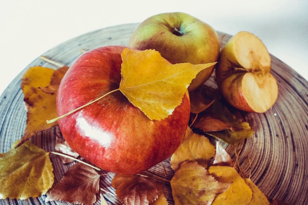 Apples and fall leaves decoration on plate. Free public domain CC0 photo.