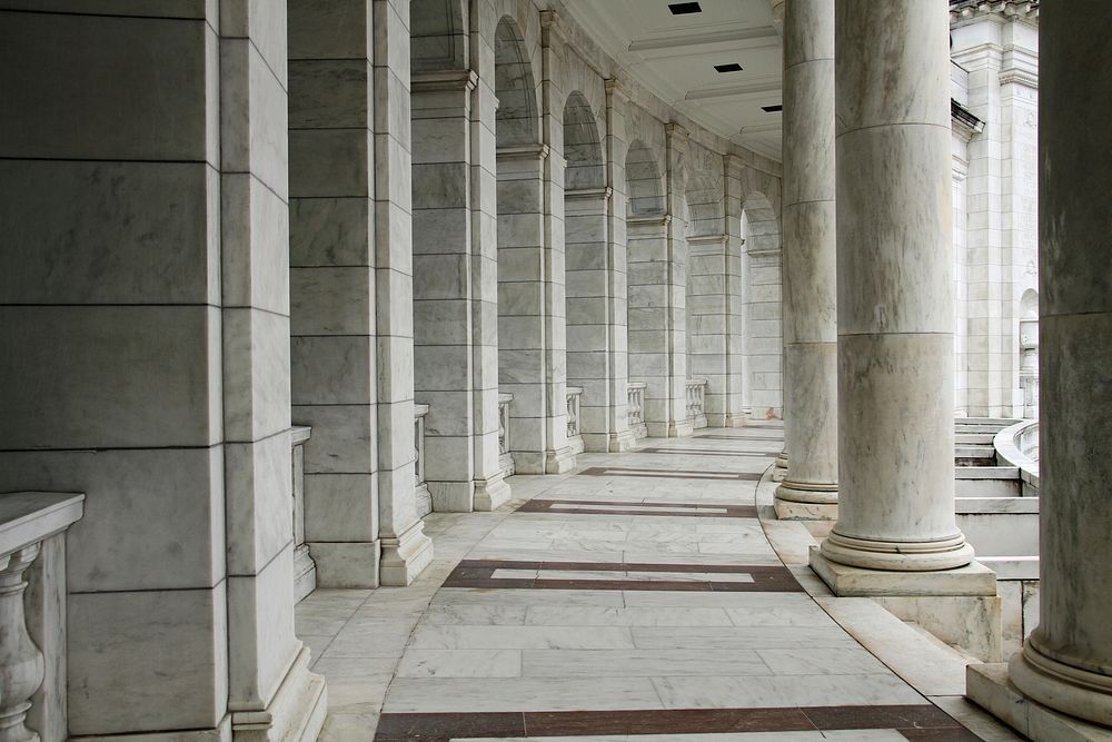 Curved row of marble pillars hallway. Free public domain CC0 image.